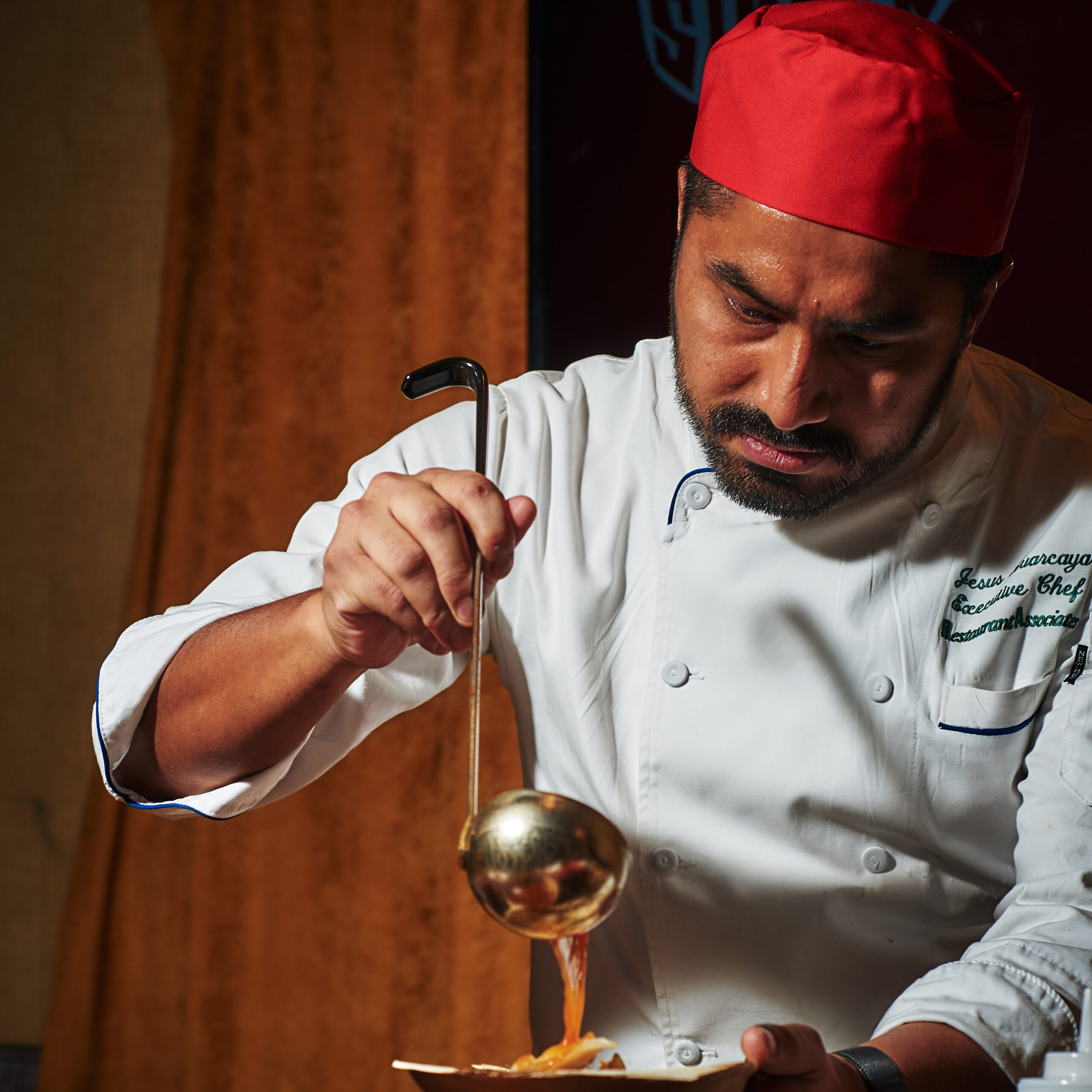 picture of male chef pouring soup